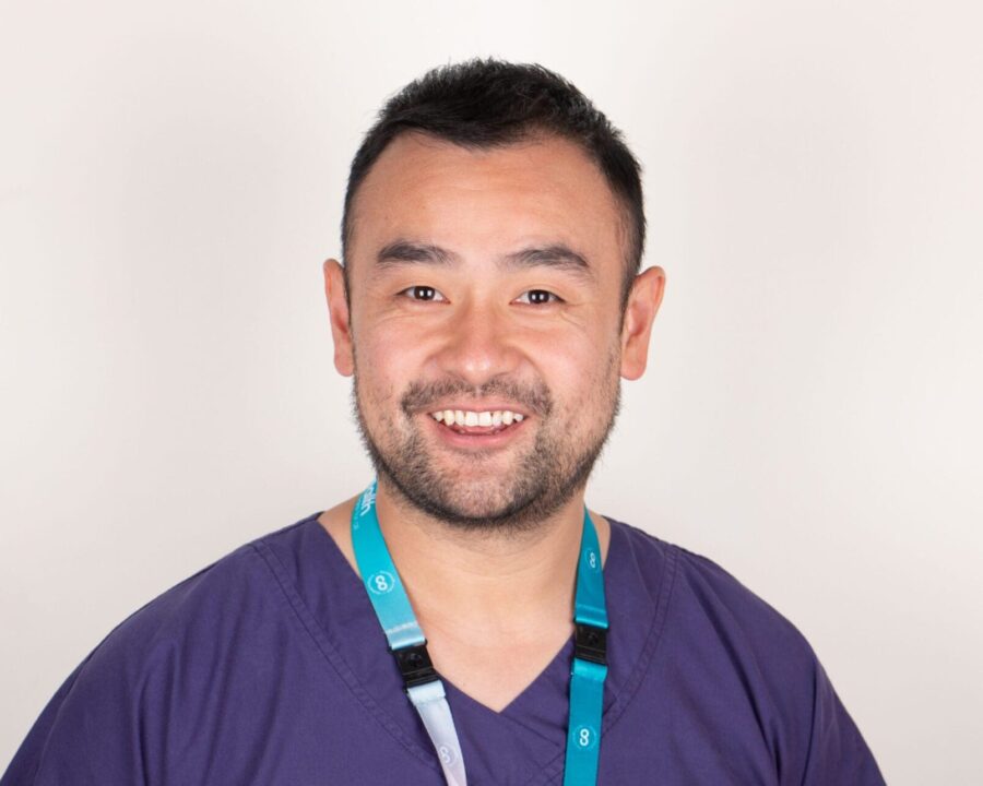 Picture of Dr Chen, who is smiling at the camera and wearing purple scrubs a cohealth lanyard